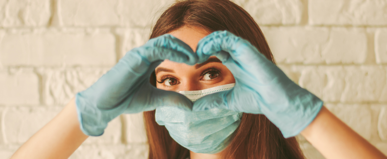 Banner of happy woman looks through hands in form of heart stock photo